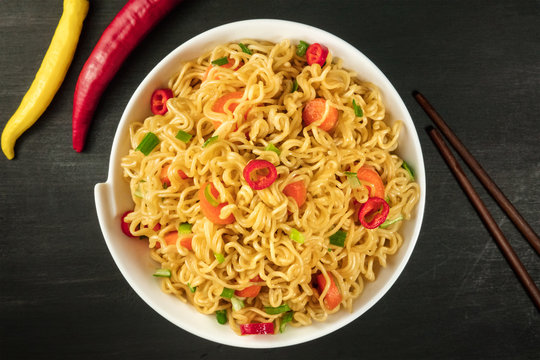 Instant noodles with vegetables, chopsticks, and copy space