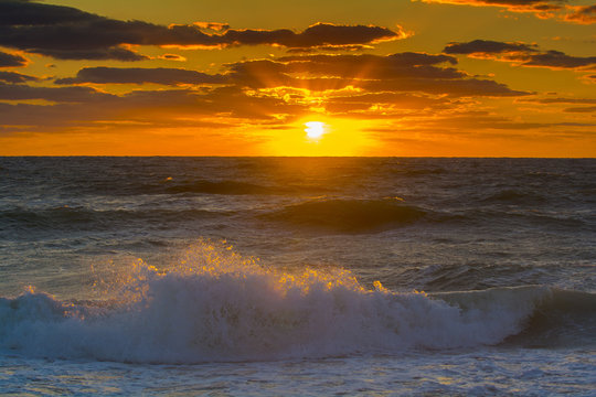 ocean sunset latge golden ball setting to ocean 