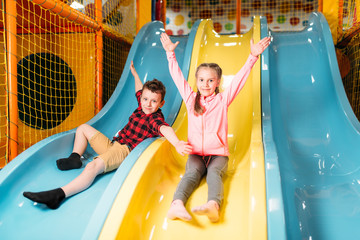 Kids riding from childrens slides in game center