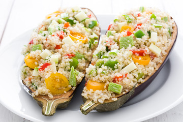 stuffed eggplant with quinoa and vegetables on white wooden table