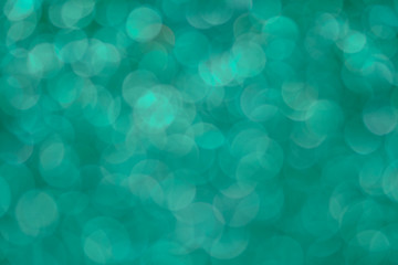Bright and abstract blurred green bokeh background with shimmering glitter
