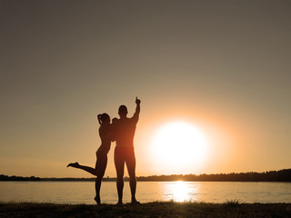 Silhouettes of a loving couple on the beach. Sunset on the beach