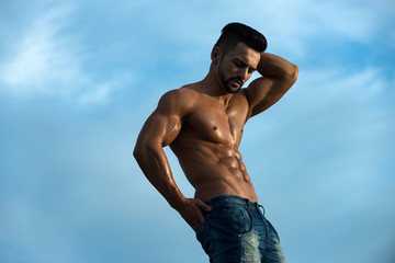 sexy man with muscular body on blue sky