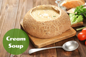 Delicious cream soup in bread on table
