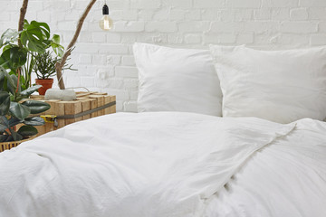 urban loft bedroom white bed linen and creative nighstand with plants