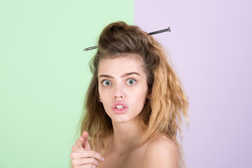 Obraz premium Surprised cute girl with naked shoulders pointing finger