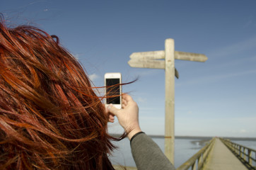 Frau macht Foto mit Handy im Urlaub