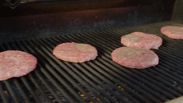 Close up panning shot of hamburgers cooking on barbecue grille. Cedar Hills, Utah, United States