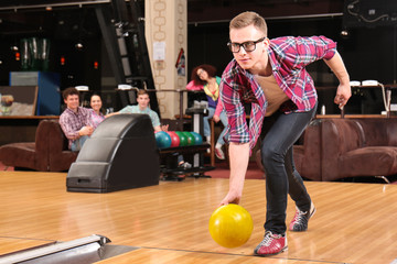 Young man having fun and playing bowling