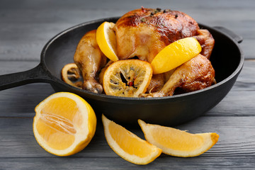 Homemade baked chicken with lemon on wooden table
