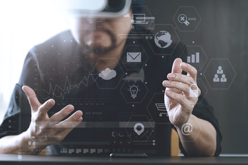 businessman wearing virtual reality goggles in modern office with mobile phone using with VR headset with screen icon diagram