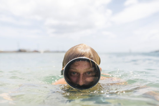 Man wearing swimming goggles swimming in sea