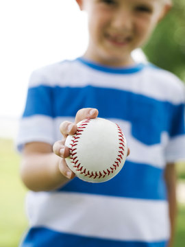 Close-up of kid's hand holding baseball