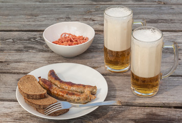 Glasses for beer and grill sausages  on a table