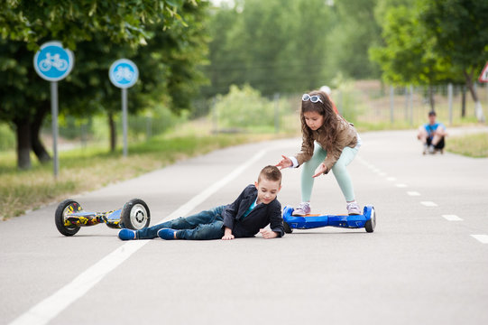 little boy and girl ride on mini segway, self-balancing scooter board or hover board scooter in green park.Eco city 