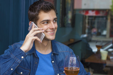 young man mobile drinking beer