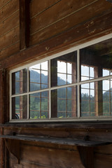 Swiss Alps behind a window of a wooden house