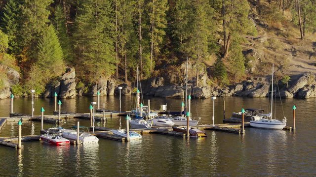 Wide shot of sailboats at dock on shimmering lake. Coeur d'Alene, Idaho, United States