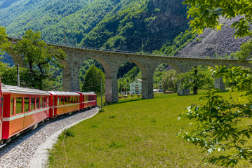 Train on the circular viaduct bridge near Brusio on the Swiss Alps - 4