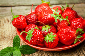 Strawberries in bowl on rustic table.