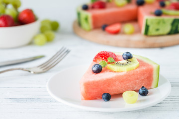 Watermelon pizza slice with fruits, white wooden background