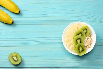 Breakfast with oatmeal porridge,  fruits on blue wooden background. Oatmeal with kiwi and banana. Healthy breakfast concept. Top view