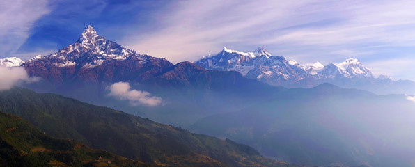 Horizontaal panoramisch uitzicht op de bergen van Mount Machapuchare, of Fish Tail, top en Manaslu Himal bij zonsopgang met de ochtendmist, op Annapurna Circuit Trek, Himalaya, Nepal, Azië