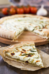 Piece of delicious asparagus pie on list of parchment.