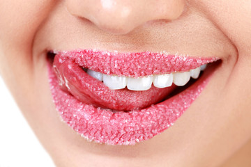 Naklejka premium Closeup of woman's lips covered with sugar. Toothy smile