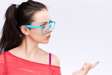 Woman in glasses looks away on a light background