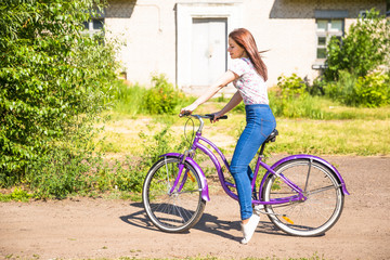 Beautiful woman with bicycle at the city park. Beautiful nature.