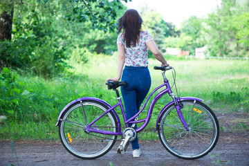 Beautiful woman with bicycle at the city park. Beautiful nature.