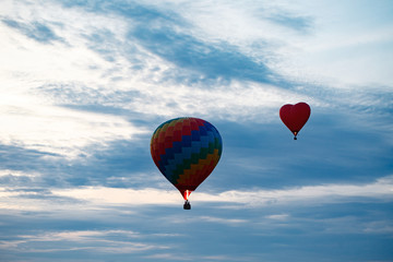 Obraz premium Colorful hot air balloon is flying at sunrise