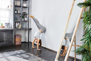 Woman practicing advanced yoga in the living room at home. A series of yoga poses