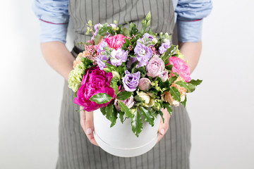 beautiful bouquet made of different flowers in young girl hand . colorful color mix flower. Work clothing in a blue shirt and gray apron