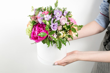 beautiful bouquet made of different flowers in young girl hand . colorful color mix flower. Work clothing in a blue shirt and gray apron