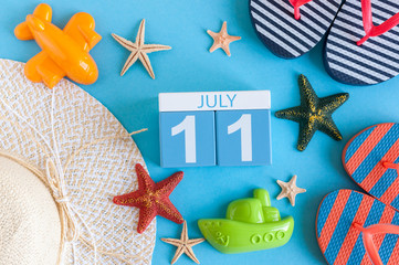 July 11th. Image of july 11 calendar with summer beach accessories and traveler outfit on background. Summer day, Vacation concept