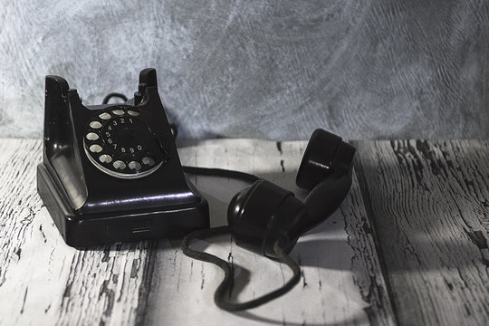 Vintage telephone on old wooden table.