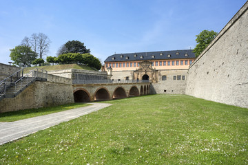 Fototapeta premium Germany, Thuringia, Erfurt, Zitadelle Petersberg, near dome, Petrini Street, Peterstor: Side view with green grass of gate and main entrance of citadel, 07 May 2017