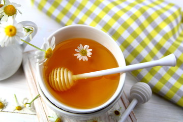 мед в керамической миске с ромашкой.вид сверху