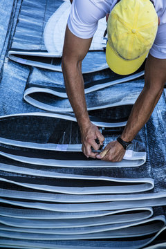 man works on sails for 12 metre North American Championships racing in Newport RI.