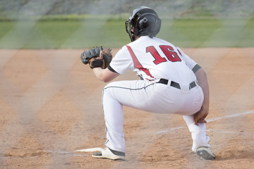 A baseball player catches for the pitcher.