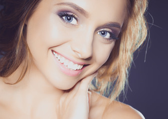 Fototapeta premium Beautiful woman with curly long hair on dark background