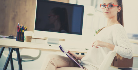 Portrait of an attractive young businesswoman sitting in front of a computer.