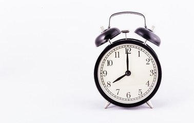 Black classic alarm clock on a white background. Black watch. Copy space