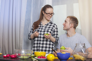 A young couple are cooking their meal