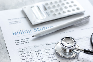 health care billing statement with doctor's stethoscope on stone background