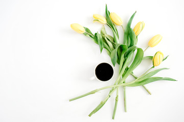 Fototapeta na wymiar Cup of coffee and yellow tulip flowers on white background. Flat lay, top view.
