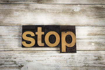 Stop Letterpress Word on Wooden Background