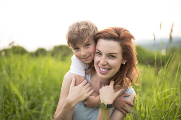 Cute kid boy with his mother on a summer meadow